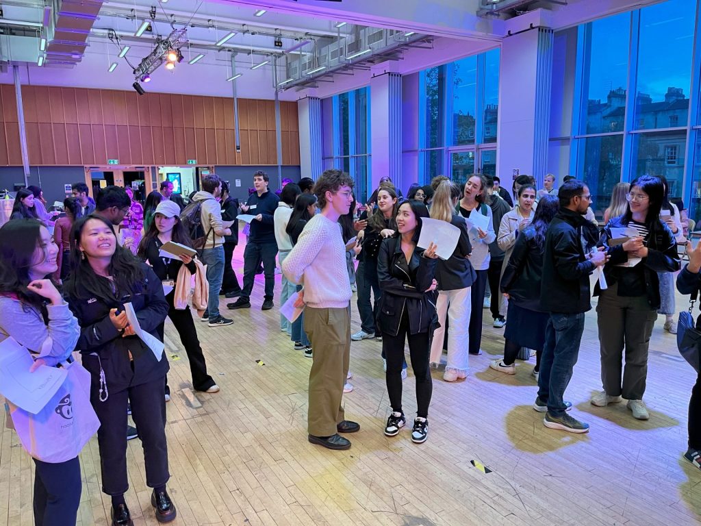 Hall full of young people talking with one another