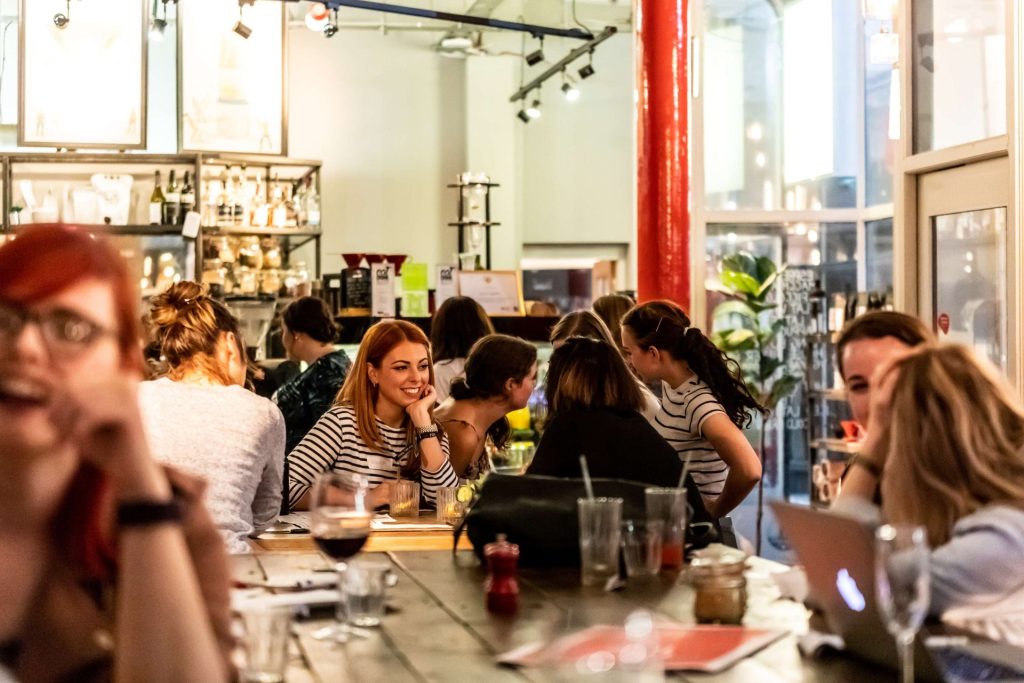 group of people smiling and conversing in a bar space